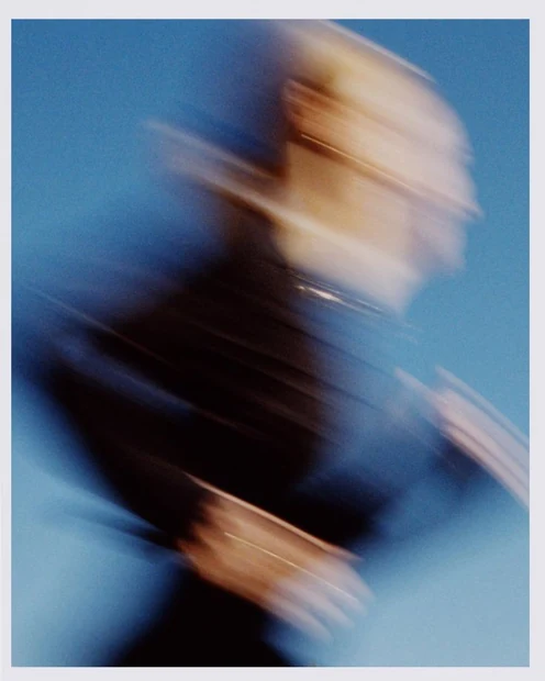 A blurred portrait against a blue sky